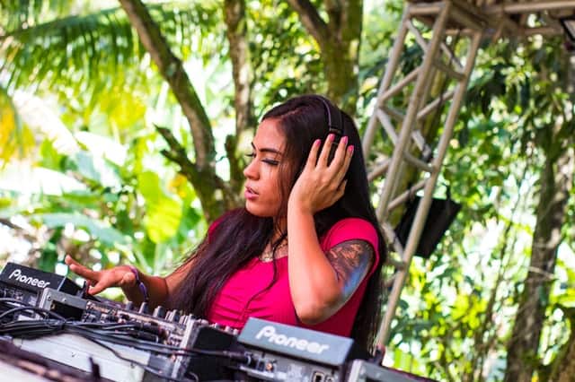 A female DJ touching her headphones